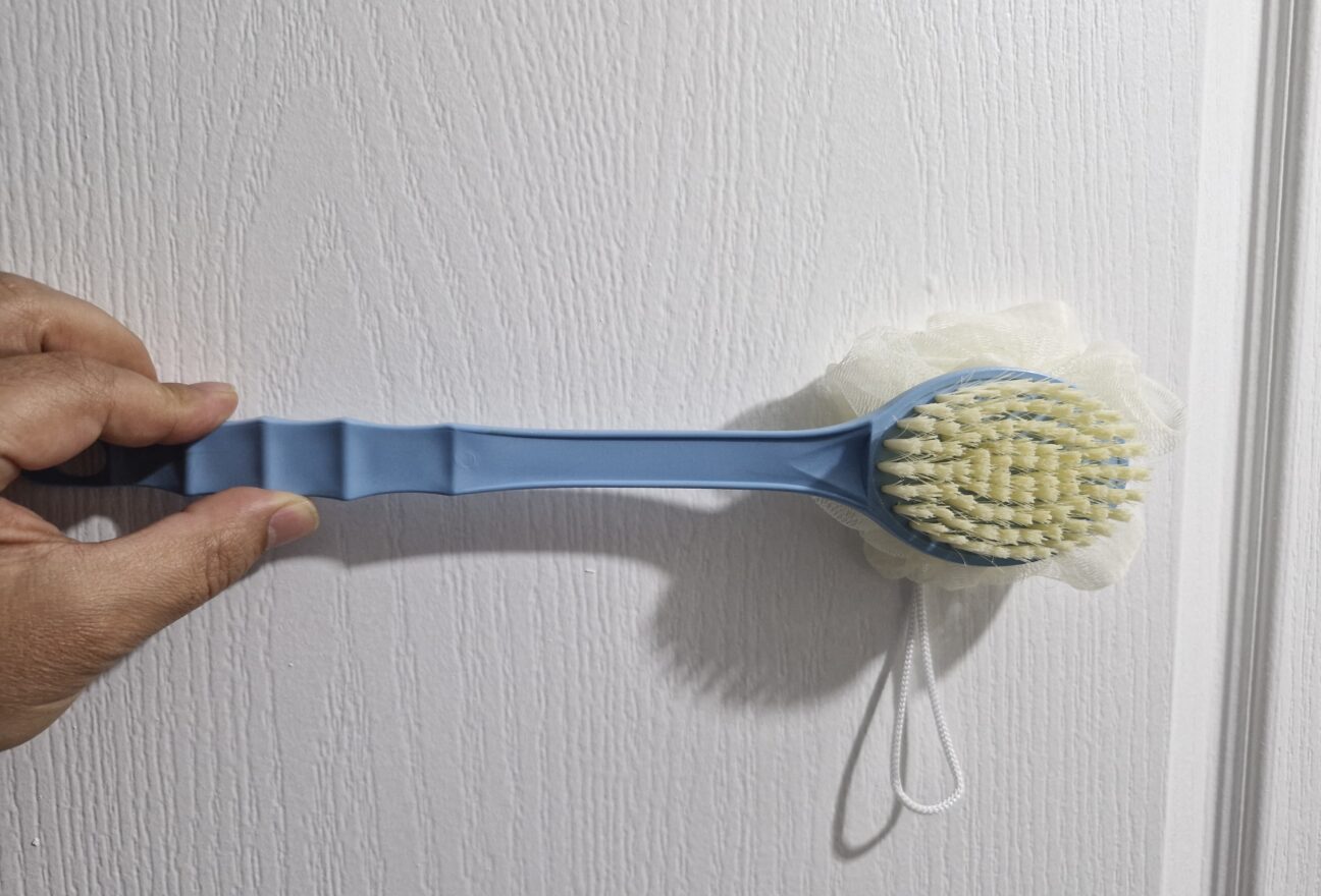 Double-headed bath brush with soft plastic handle and compact brush surface.
Overview of a double-headed body brush, highlighting the small brush size and overly flexible handle which affects usability.