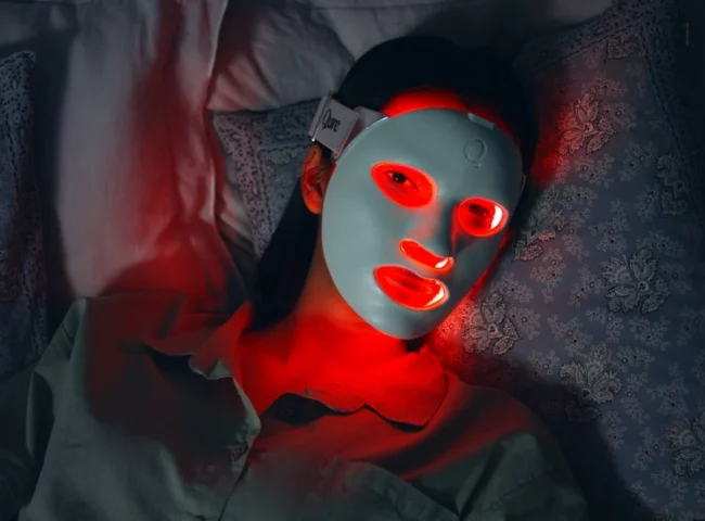 LED skincare mask glowing red while applied on face
