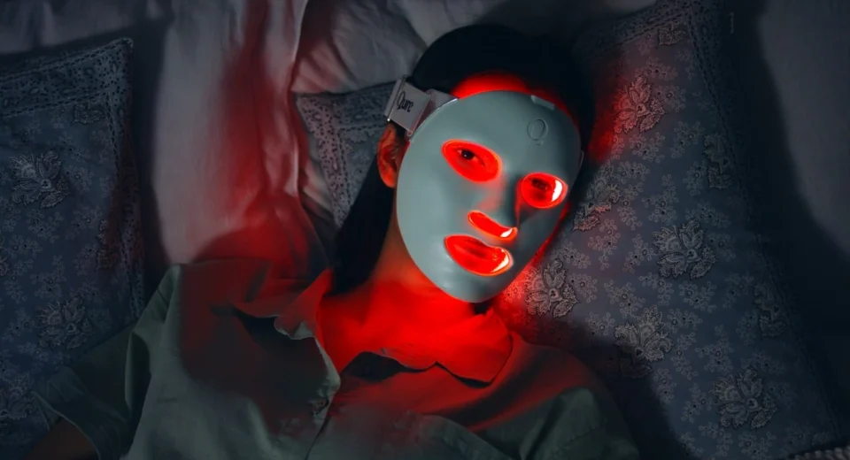 LED skincare mask glowing red while applied on face